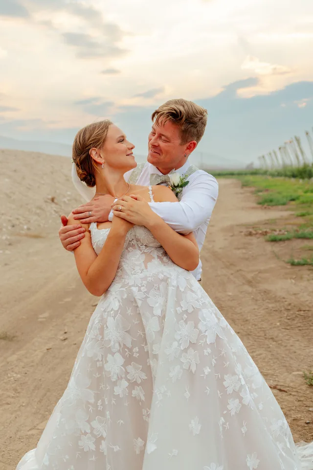 Bride and groom embracing in an orchard at golden hour on their wedding day